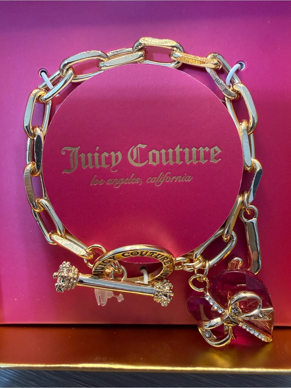 Juicy Couture Gold-Tone Toggle Bracelet with Pink Logo Backdrop